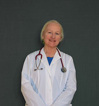 Photograph of the doctor wearing a lab coat and stethoscope, smiling. 